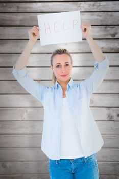 Pretty blonde holding help sign  against wooden planks