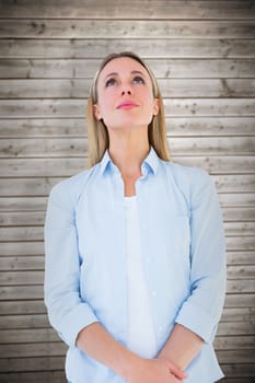 Portrait of blonde woman posing and looking up against wooden planks background