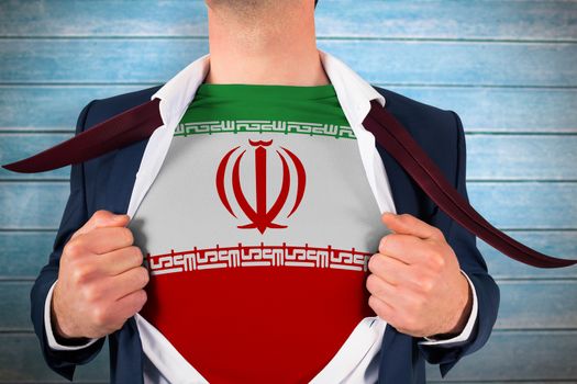 Businessman opening shirt to reveal iran flag against wooden planks