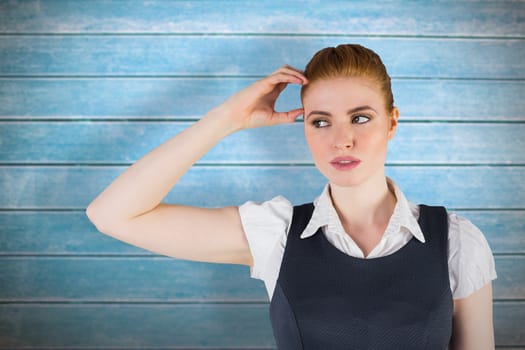 Thinking redhead businesswoman against wooden planks