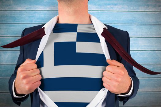 Businessman opening shirt to reveal greece flag against wooden planks