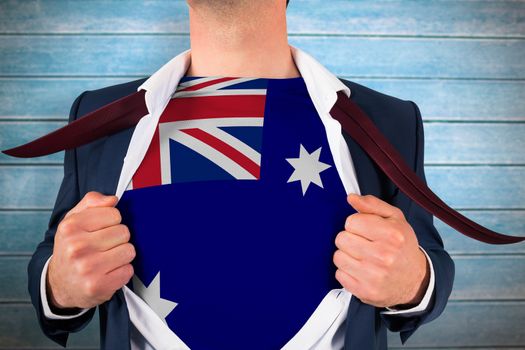 Businessman opening shirt to reveal australia flag against wooden planks