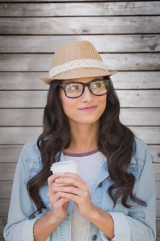 Brunette with disposable cup against wooden planks