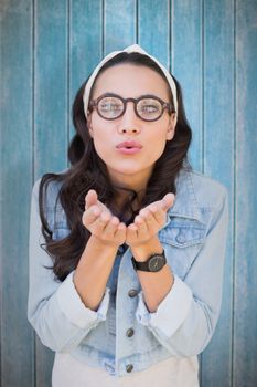 Brunette blowing kiss against wooden planks