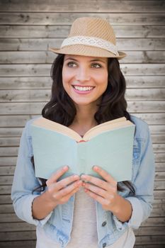 Brunette reading against wooden planks background