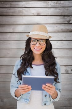 Brunette with tablet pc against wooden planks
