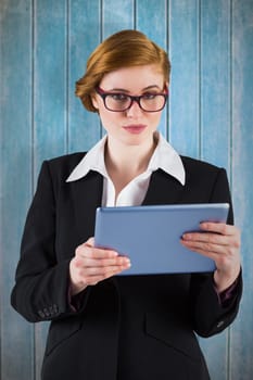 Redhead businesswoman using her tablet pc against wooden planks