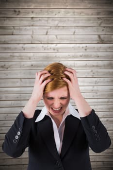 Stressed businesswoman with hands on her head against wooden planks background