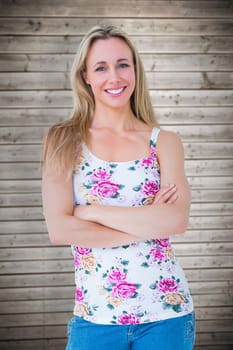 Portrait of pretty blonde posing with arms crossed against wooden planks background