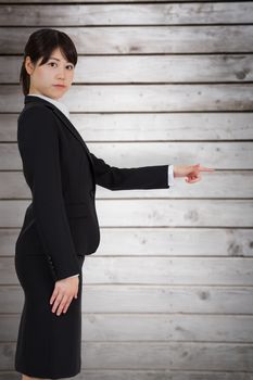 Focused businesswoman pointing against wooden planks