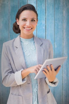 Brunette using tablet pc against wooden planks