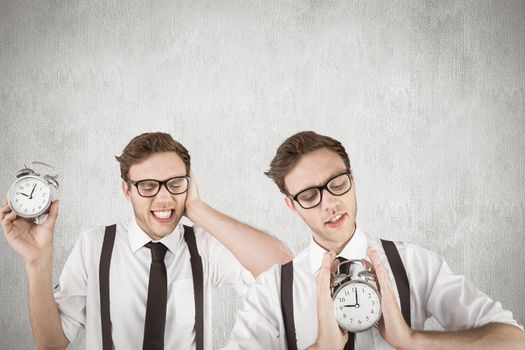 Nerdy businessman with alarm clock against white and grey background