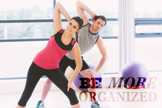 Two people doing power fitness exercise at yoga class against be more organised