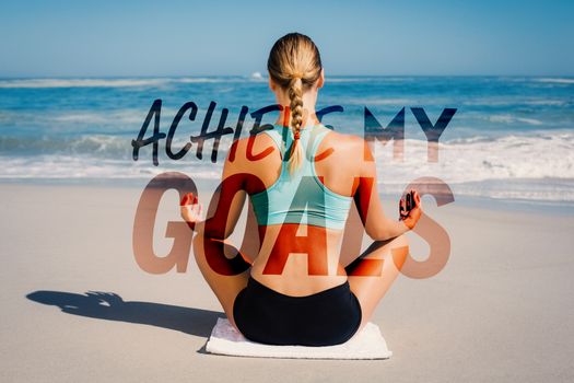 Fit woman sitting on the beach in lotus pose against achieve my goals