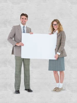 Hipster couple holding poster smiling at camera against white background