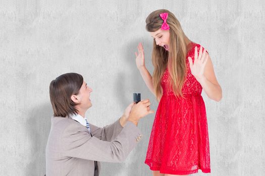 Hipster on bended knee doing a marriage proposal to his girlfriend  against white background