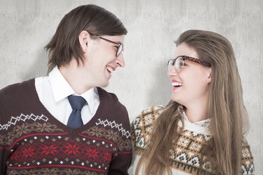 Happy geeky hipster couple looking at each other against white background