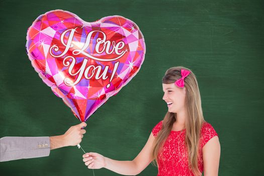Geeky hipster offering red heart shape balloon to his girlfriend against green chalkboard