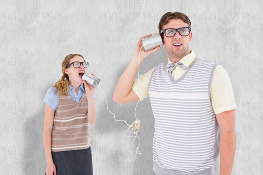 Geeky hipster couple speaking with tin can phone  against white background