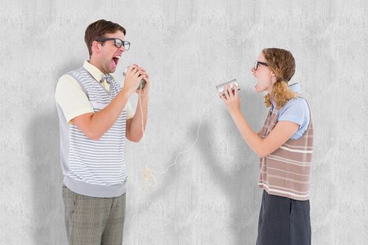 Geeky hipster couple speaking with tin can phone  against white background