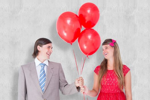 Smiling geeky couple holding red balloons against white background