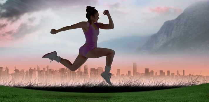 Fit brunette running and jumping against sun shining over city