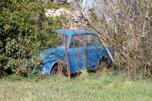 abandoned old blue car in yard