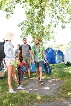 Excited friends arriving at music festival on a summers day