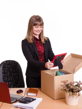 The girl accepted a job at the office and arranges personal belongings at the new workplace