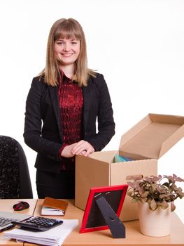 The girl accepted a job at the office and arranges personal belongings at the new workplace