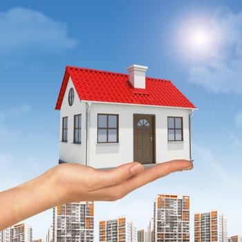 White house in hand with red roof, chimney. Background building, sun shines brightly on right