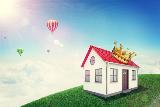 White house with red roof, brown door and crown on green grassy hill. Background sun shines brightly and flying hot air balloon. Blue sky