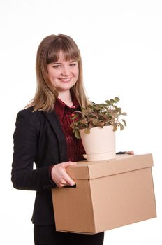 Smiling girl adopted at work in the office holding a box with things