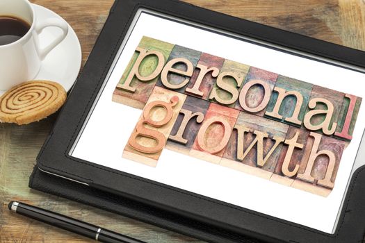 personal growth typography - text in letterpress wood type on a digital tablet with a cup of coffee