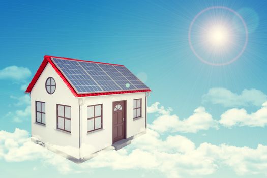 White house with red roof, brown door and solar panels  in cloud. Background sun shines brightly on large clouds