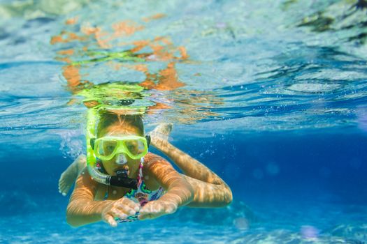 Underwater shoot of a cute girl snorkeling in a tropical sea