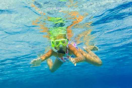 Underwater shoot of a cute girl snorkeling in a tropical sea