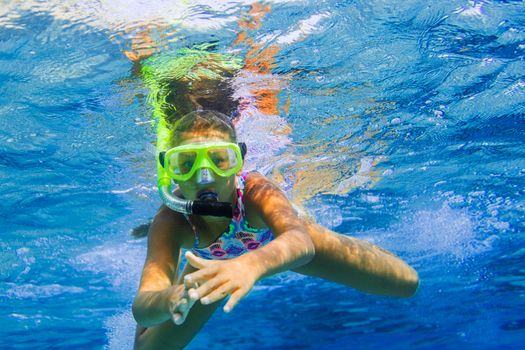 Underwater shoot of a cute girl snorkeling in a tropical sea