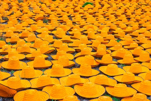 Many Orange Bamboo Farmer Hats on Ground.