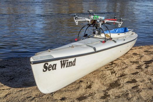 WILDCAT, CO, USA, March 9,  2015:  DJI F550 Flame Wheel  hexacopter drone with camera is taking off from a canoe deck on a river shore.