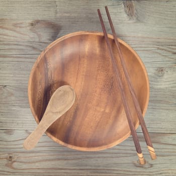 Overhead view of empty plate and sushi chopsticks on old wooden table. View of dining setting in vintage mood. Square composition.