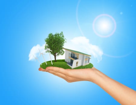 White cottage in hand with green roof. Background sun shines brightly on right. Blue sky