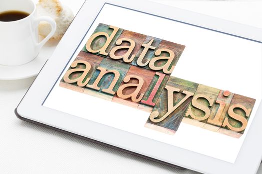 data analysis - text in letterpress wood type blocks on digital tablet with cup of coffee