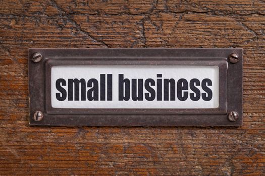 small business   - file cabinet label, bronze holder against grunge and scratched wood