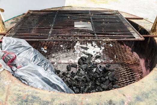 Wood Coal with Ash on Grate in Fireplace.