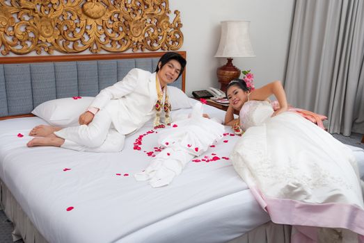 Asian Thai Bride and Groom on a Bed in Wedding Day.