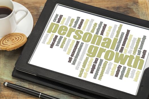 personal growth word cloud on a digital tablet with a cup of coffee