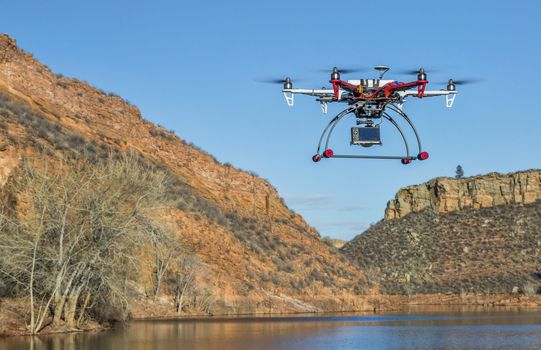 FORT COLLINS, CO, USA, February 18,  2015:  F550 Flame Wheel  hexacopter drone is  flying with a camera over mountain lake