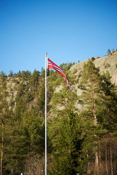 Norwegian pennant on a pole with mountains background