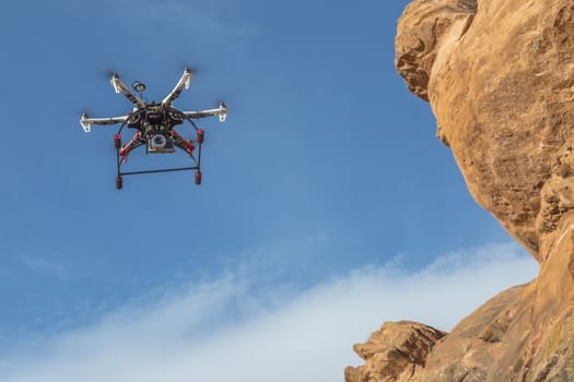 FORT COLLINS, CO, USA, February 12,  2015:  F550 Flame Wheel  hexacopter drone is  flying with a camera along sandstone cliff.